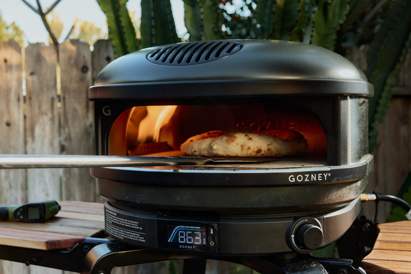 GOZNEY pizza oven with a pizza inside, outdoors.