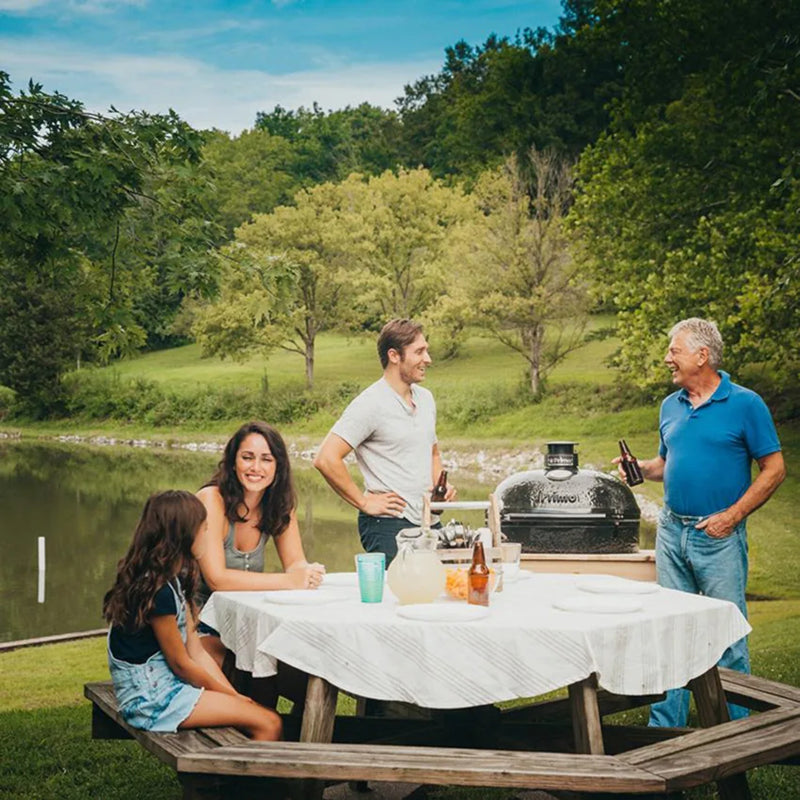 Primo Oval XL 400 Ceramic Kamado Grill On Curved Cypress Table With Stainless Steel Grates | GW STORE
